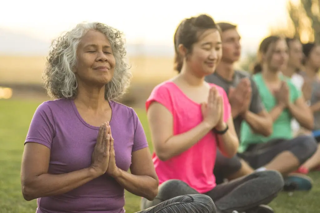 senior woman with a group of people meditating
