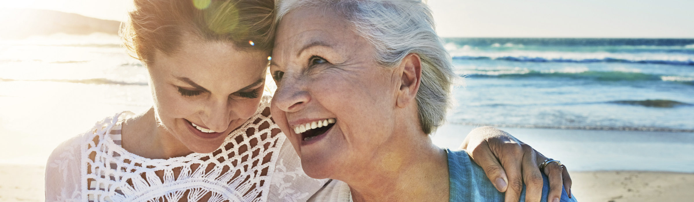 Older woman with her adult daughter on the beach