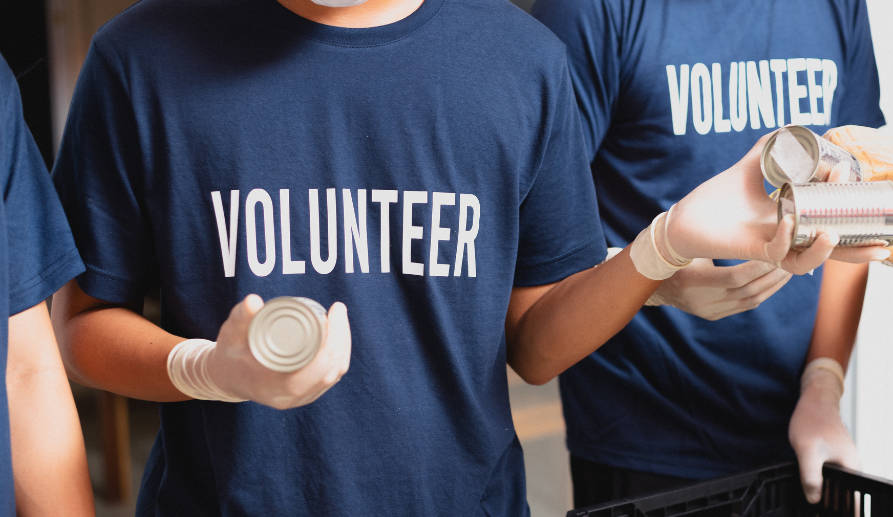 Individuals wearing blue volunteer t-shirts at The Village At Duxbury, a senior living community.