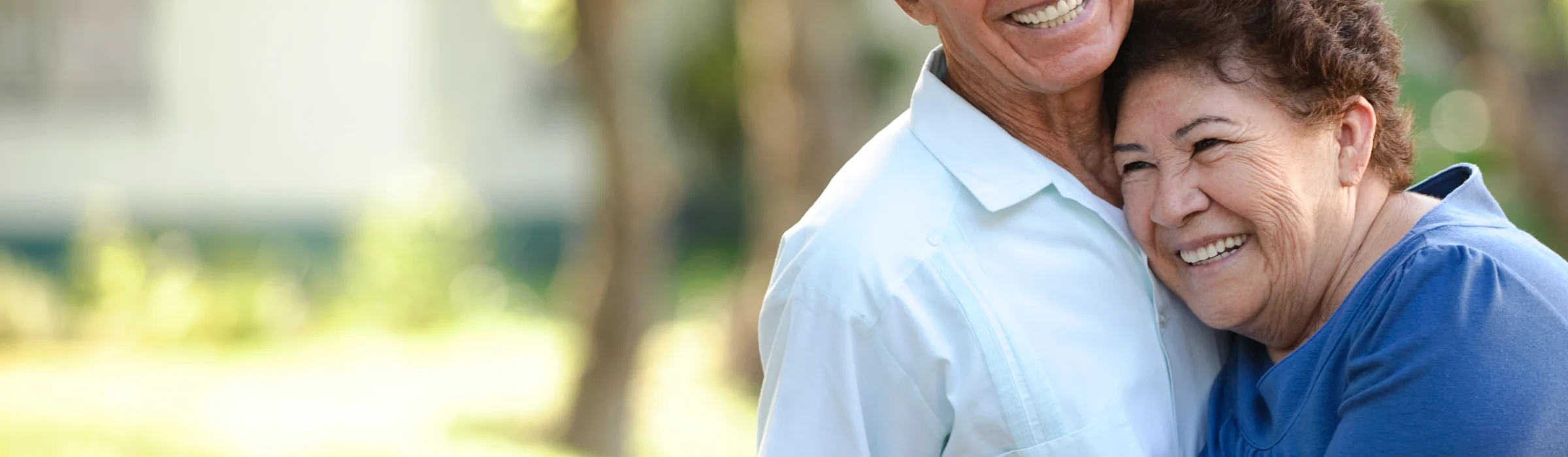 A senior couple hugging outside of The Village at Duxbury in MA, while discussing what is independent living for seniors.
