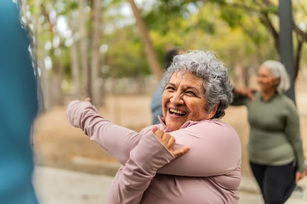 What Is Independent Living for Seniors? Enjoy Freedom, Community, and an Active Retirement 2 A senior woman stretching outside of The Village at Duxbury, while exploring what is independent living for seniors in MA.