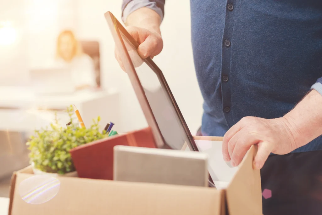 senior man packing a photograph into a box and downsizing for retirement in Massachusetts
